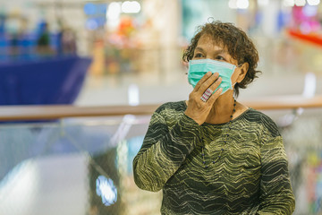 Old asian woman in a mask for COVID-19, for protection against the crown virus. Asian senior woman with protective mask because dirty air smog, PM2.5. Coronavirus old woman walking with surgical mask