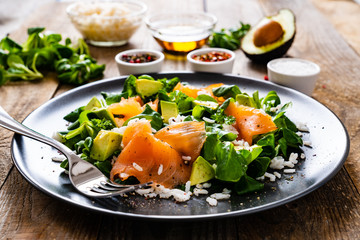 Salmon salad - smoked salmon white rice and vegetables on wooden table