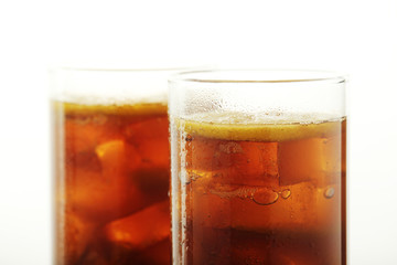 Glasses with cuba libre cocktail or cola with ice or cold tea with lemon