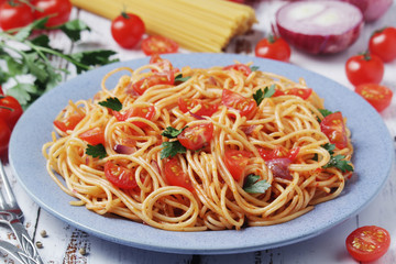 A plate with spaghetti with tomatoes