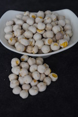 White roasted chickpeas in a bowl and poured in front of it.