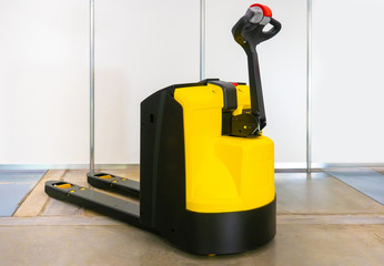 Electric pallet transporter. Cargo trolley. Loader. Electric trolley. Work in a warehouse. Transportation of goods. Pallet carrier escorted. Modern equipment for the warehouse. Warehouse Stacker.