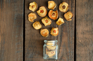 Dried pear from small glass bottle on wooden background