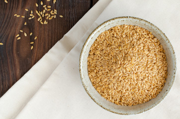 Canadian flax-seeds in bowl and linen on wooden background. Top view