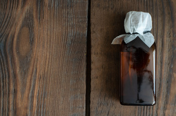 cough-drop in small dark bottle on wooden background with copy space.