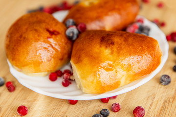 Appetizing homemade pies with berries on a saucer. Close-up.