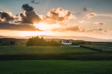 Fototapeta na wymiar A quiet sunset view of a farmhouse in Scottish Highlands, Isle of Skye