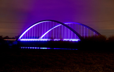 Long exposure of Toome bridge over the River Bann at night with blue and purple lights and some car red tail lights, Toomebridge, County Londonderry, Northern Ireland