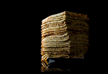 Shrovetide Maslenitsa Butter Week festival meal. Stack of russian pancake blini on a dark rustic...