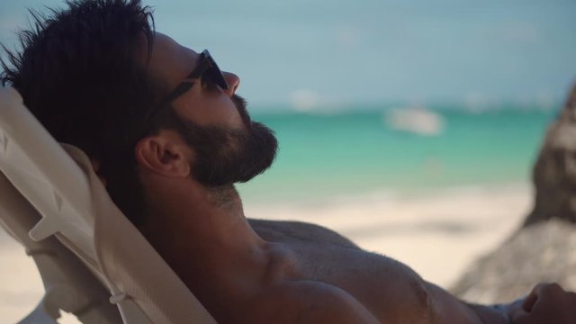Man Relaxing On Vacation Caribbean Tropical Beach.Happy Businessman Resting Beach Hotel Luxury.Beautiful Man Lies On Sunbed On Vacation.Summer Sunbathing Resort Sea Or Ocean.Guy Lying On Sun Lounger