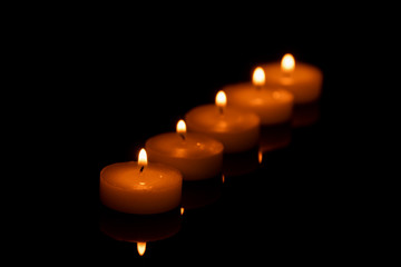 some beautiful burning candles with shallow depth of field in the dark in the rain, very beautiful, warm, Christmas mood, festive mood, wax candles