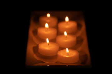some beautiful burning candles with shallow depth of field in the dark in the rain, very beautiful, warm, Christmas mood, festive mood, wax candles