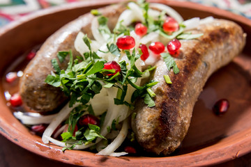 Grilled sausage in a clay pot. Georgian restaurant.