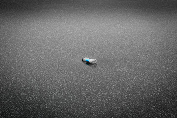 Plastic bottle pollution on lake ice covered by snowflakes as a sigh of human negligence and carelessness 