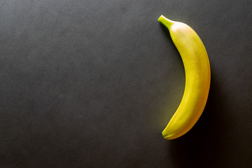 Yellow background design. Bananas isolated on black with copy space. View from above.