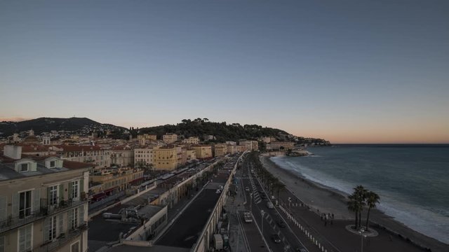Day to night time-lapse of full moon rising over old town of Nice and Promenade des Anglais