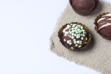 Chocolate Potato Cake. Some decorated with sprinkles, others with chocolate. On white background.