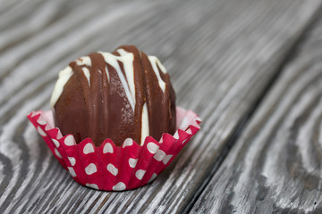 Chocolate Potato Cake. Garnished with trickles of chocolate. Against the background of brushed boards.