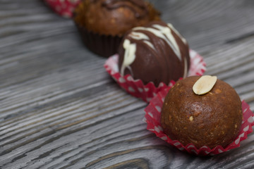 Chocolate Potato Cake. Garnished with walnut, trickles of chocolate or sprinkled. Against the background of brushed boards.