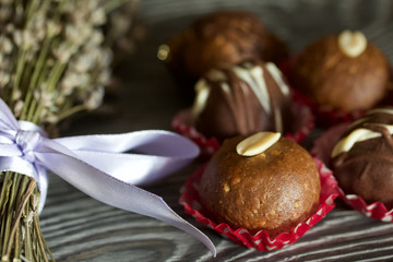 Chocolate Potato Cake. Garnished with walnut, trickles of chocolate or sprinkled. Near a bouquet of lavender. Against the background of brushed boards.
