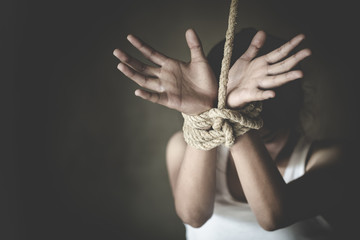 Kidnapped woman tied with rope, abused, hostage, victim woman in pain, Human trafficking, Human rights.