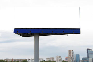 Billboard horizontal on the background of the city, cloudy sky.