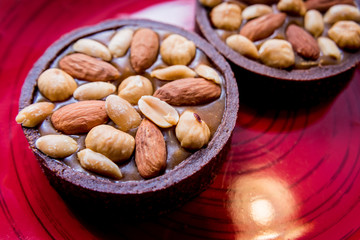 Chocolate cookies with almond nuts on a red plate. Restaurant.