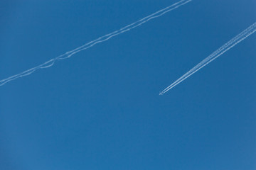 Traces of high-flying passenger aircraft. Day, blue sky.