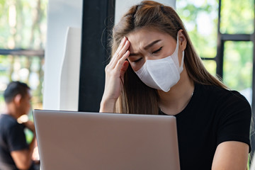 Business Asian young woman working with computer laptop and wearing protection mask coughing have...