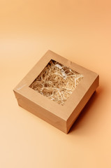 craft gift box inside with paper hay on a beige background, isolate. Copyspace. The concept of sales, discounts, Christmas gifts and shopping.