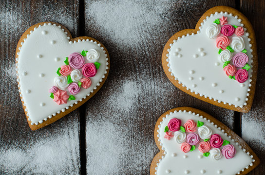 Gingerbread hearts and icing sugar on wooden background. Top view.