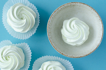 Marshmallow in cup on blue background. Top view