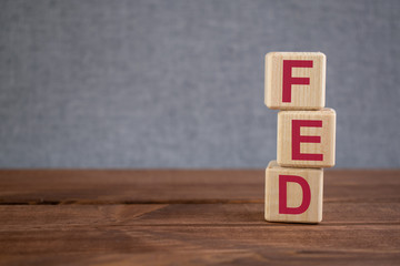 FED, Federal Reserve, the institution to control US financial banking concept, acronym on wooden cubes on dark wooden backround.