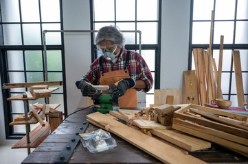 Fototapeta premium Carpenter working on woodworking machines in carpentry shop, wooden product