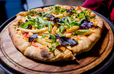 Tasty pizza with chicken and vegetables. Restaurant.