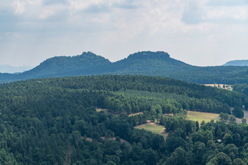 Naklejka premium Königstein fortress on the banks of the Elbe river, green landscape with mountains in the background. Dresden, Saxon Switzerland, Germany.