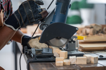 The carpenter is using the tools to work in the wooden studio.
