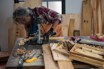 The carpenter is using the tools to work in the wooden studio.