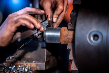 Industrial engineering, wearing safety clothing, using vernier calipers, measuring instruments, controlling objects working in industrial plants, shop, lathe shop