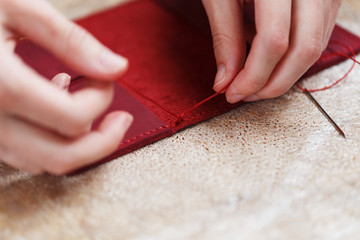 Conceptual profession of a Tanner. The woman's hands closed around the needle and thread.