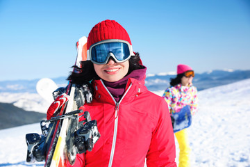 Fototapeta na wymiar Young woman with ski at resort. Winter vacation