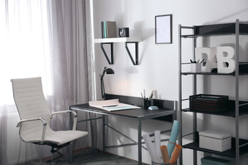 Stylish room interior with comfortable workplace near window. Design idea