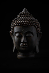 Meditating Buddha Statue isolated on black background. 