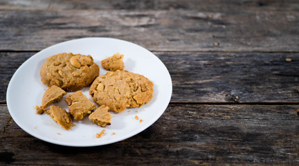 Cracked cookies on a plate on a wooden background