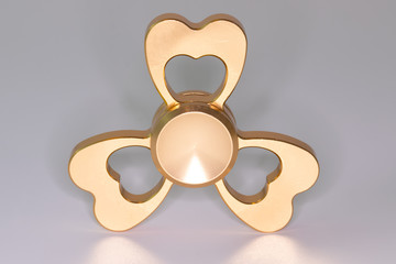 Golden spinner stress relieving toy on white background