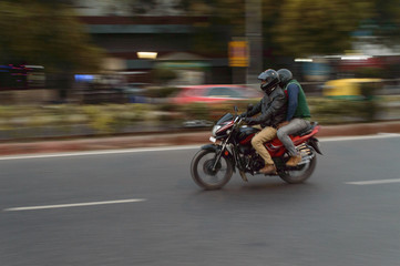 panning technique of red and black bike going somewhere at evening on the road