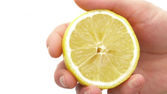 Close-up of male hand holding a part of cut juicy fresh lemon. Organic citrus fruit. Isolated, on white background