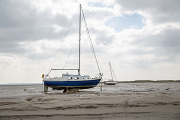 Fisherman boats stuck on the beach in low tide period.