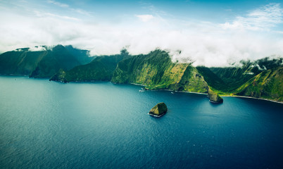 Beautiful Aerial View of Tropical Island Paradise Nature Scene of Maui Hawaii On Clear Sunny Day with Vibrant Blue Ocean Water and Waves and Lush Green Mountain Scenic Landscape with Big Rock in Sea - obrazy, fototapety, plakaty