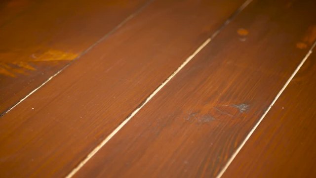 Scratched pine wood flor close up slider shot, camera movement from left to right.